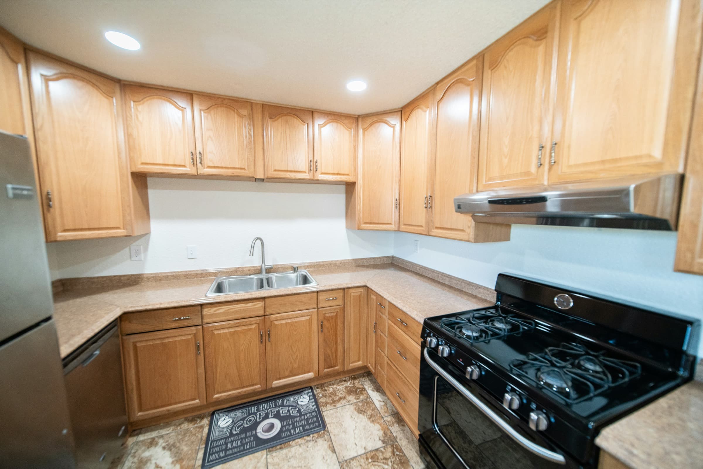 Dated kitchen with honey oak cabinets and laminate counters